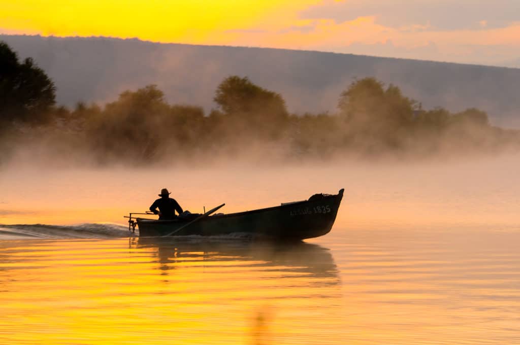 fishing boat on foggy lake