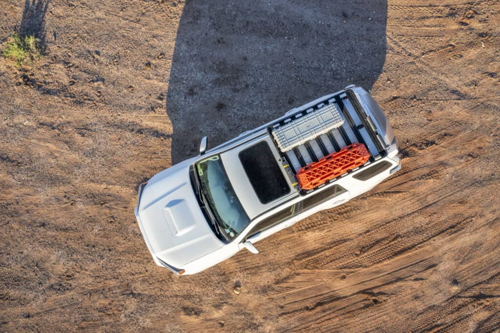 Hanksville, UT, USA - May 19, 2021: Aerial view of Toyota 4Runner SUV (2016 Trail model) with recovery ladders and a gun case aka cargo box on roof racks a desert trail.