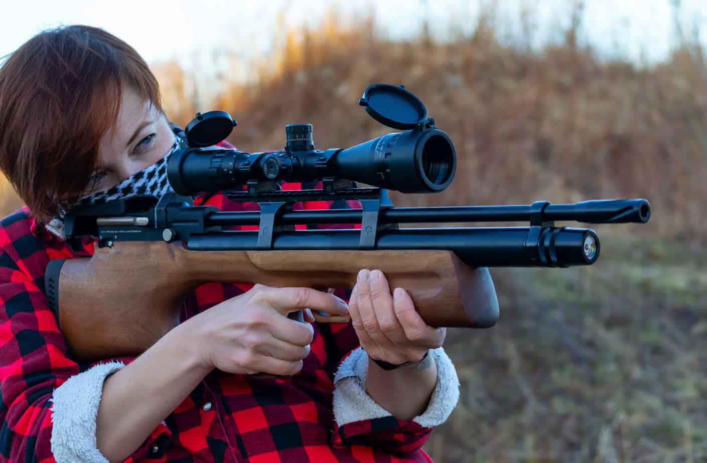 person aiming a pcp gun. Armed woman. Outdoor sport shooting